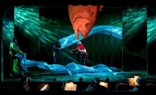 Among the tin soldier's travails is to be eaten by a fish but the fish brings him home in The Steadfast Tin Soldier at Lookingglass Theatre.